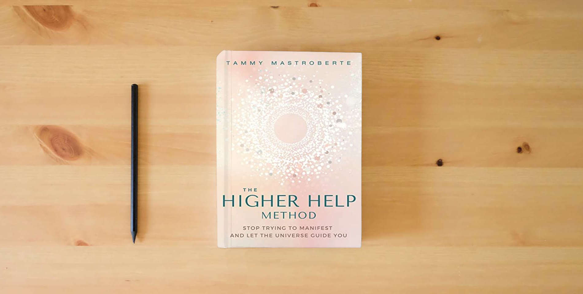 The book The Higher Help Method: Stop Trying to Manifest and Let the Universe Guide You is on the table