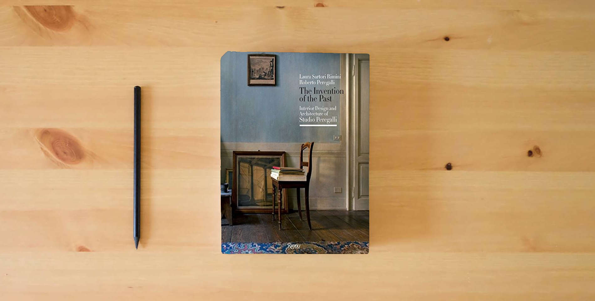 The book The Invention of the Past: Interior Design and Architecture of Studio Peregalli is on the table