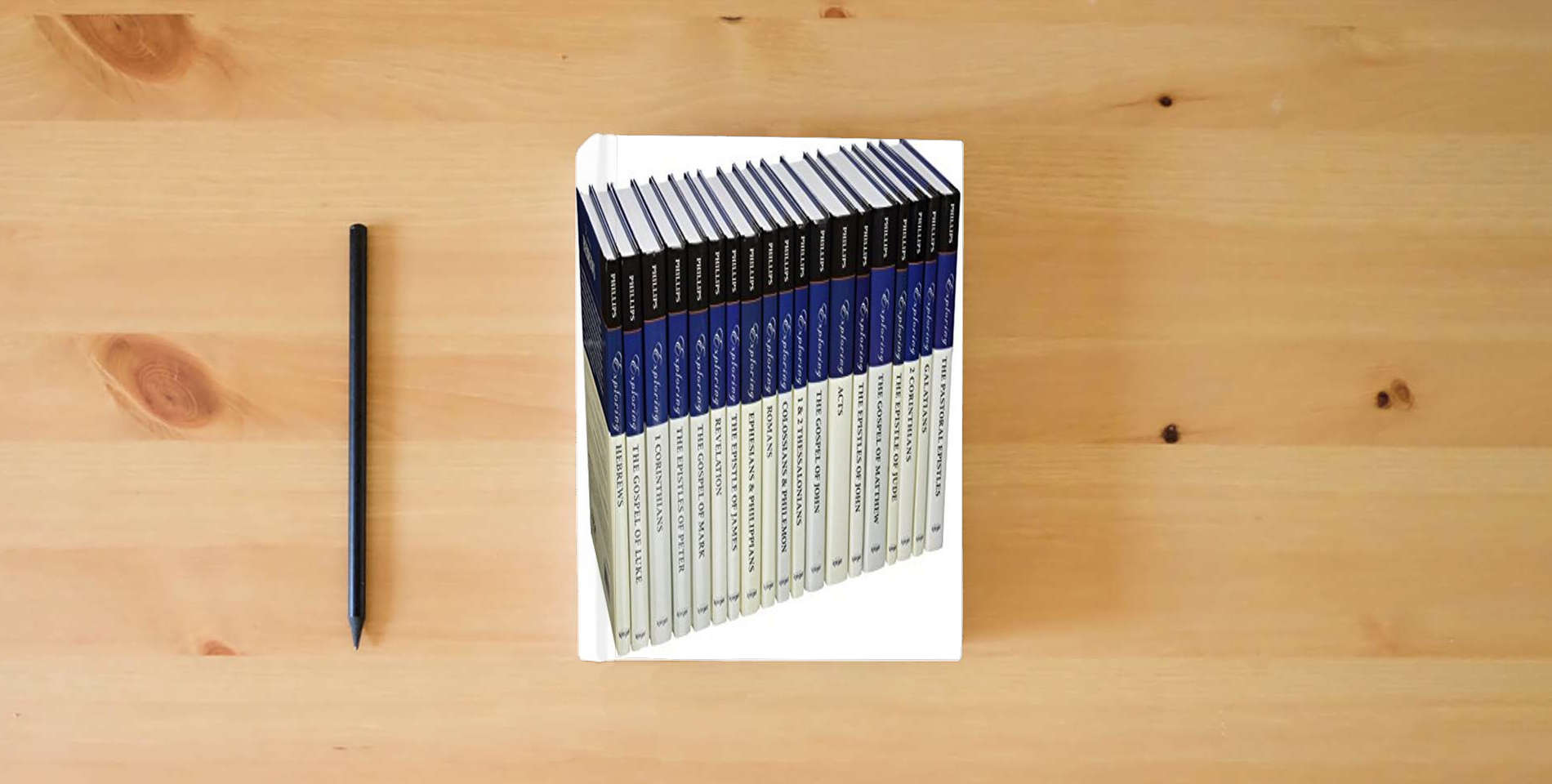 The book The John Phillips New Testament Commentary, 19 Volumes (John Phillips Commentary) is on the table