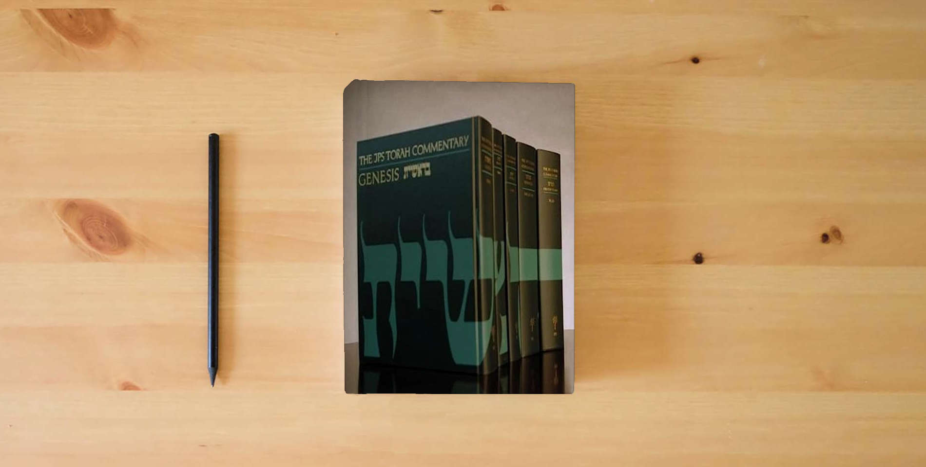 The book The JPS Torah Commentary Series, 5-volume set is on the table