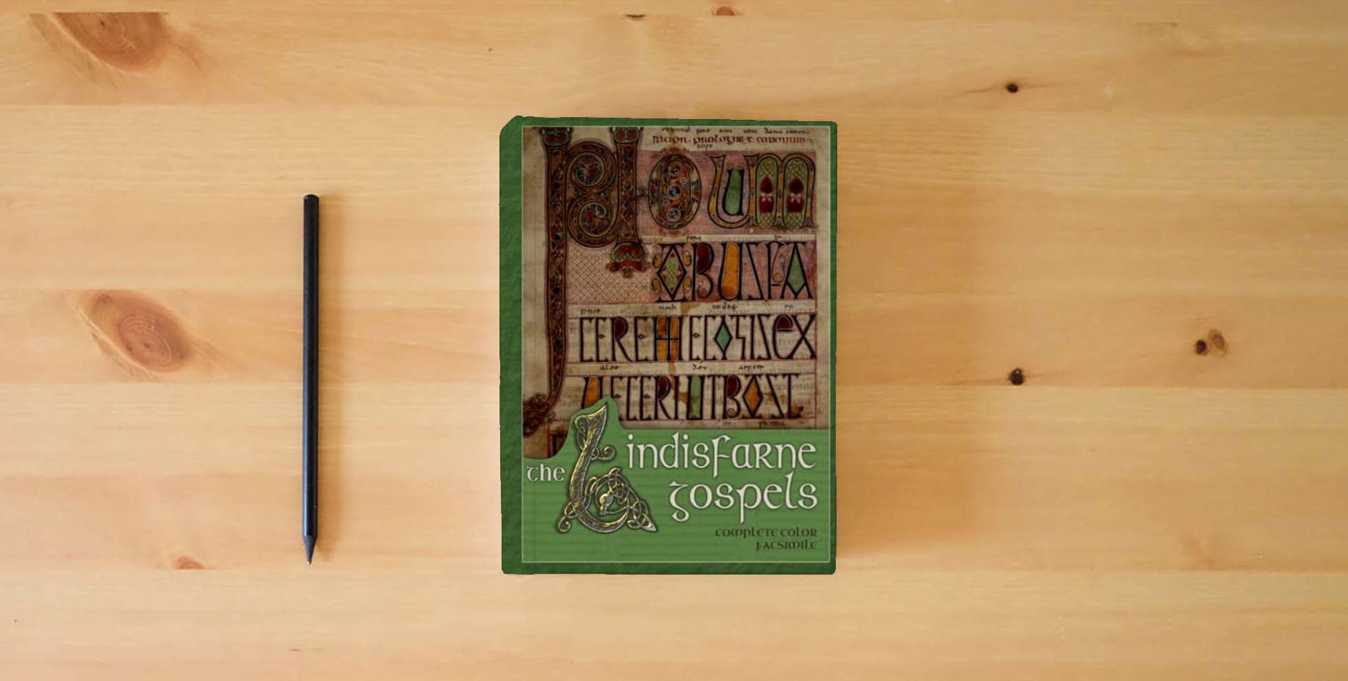 The book The Lindisfarne Gospels (Annotated): Complete Facsimile (Historical Bible Facsimiles) is on the table