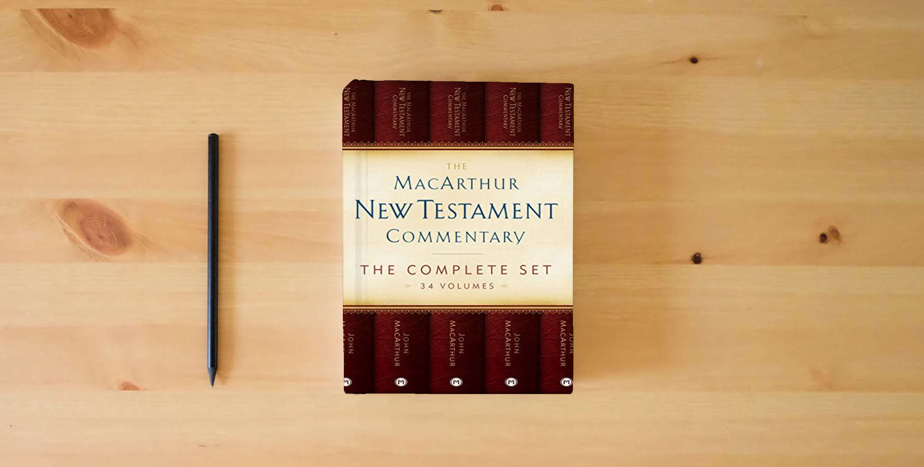 The book The MacArthur New Testament Commentary Set of 34 volumes (MacArthur New Testament Commentary Series) is on the table