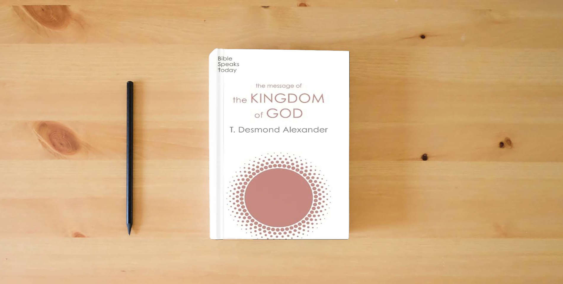 The book The Message of the Kingdom of God (The Bible Speaks Today Themes) is on the table