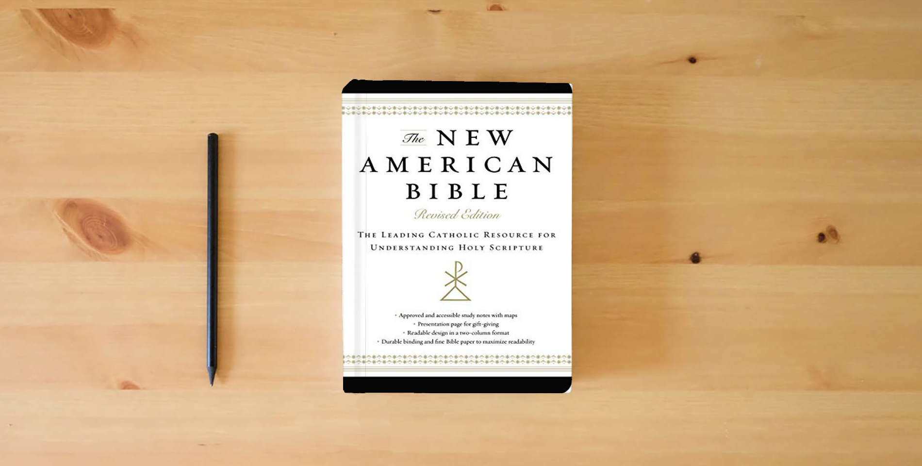 The book The New American Bible, Revised Edition, Imitation Leather, Non-flex, Black: The Leading Catholic Resource for Understanding Holy Scripture is on the table