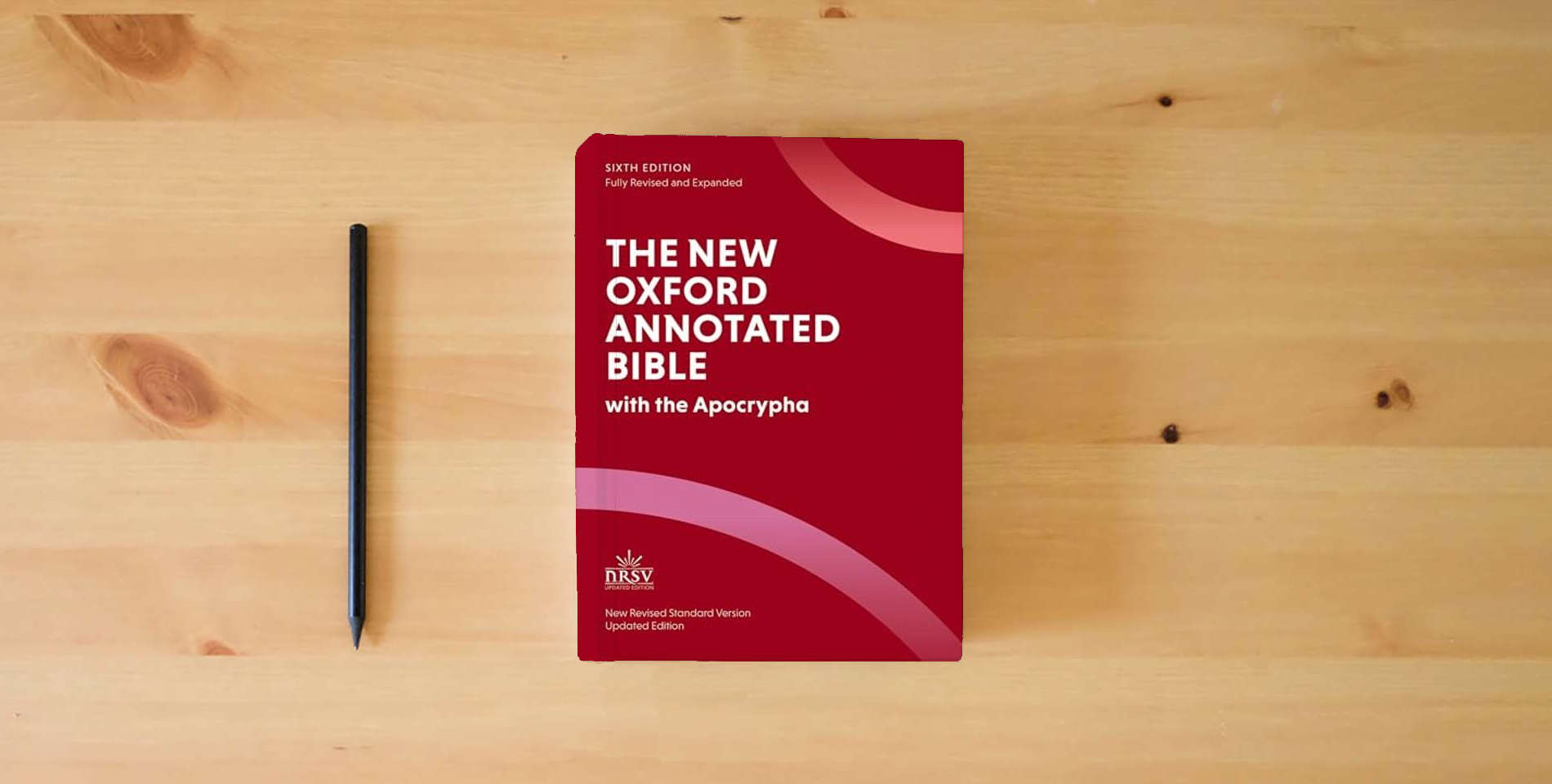 The book The New Oxford Annotated Bible: New Revised Standard Version with the Apocrypha is on the table