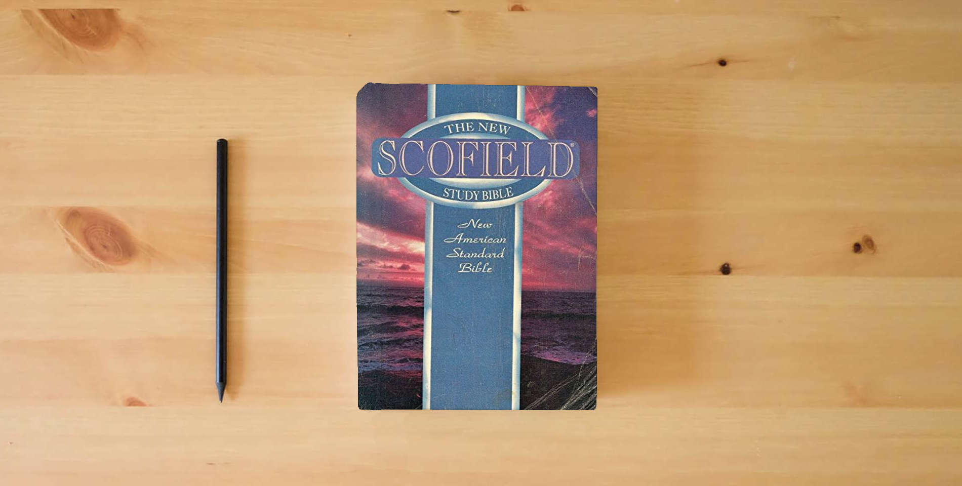 The book The New Scofield Study Bible: New American Standard Bible is on the table