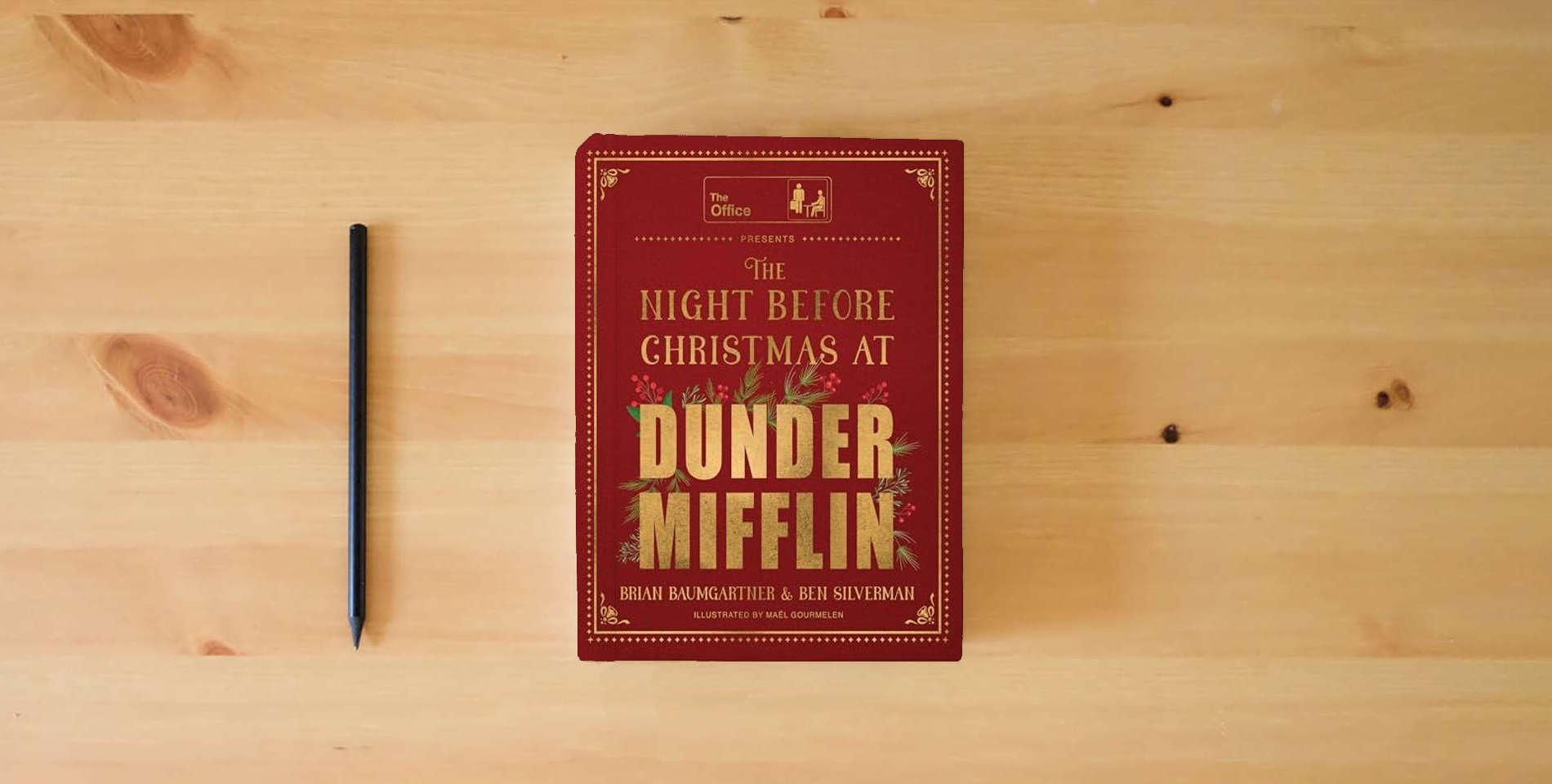 The book The Night Before Christmas at Dunder Mifflin: A hilarious and heartwarming retelling of a Christmas classic and perfect holiday gift for fans of The Office. is on the table