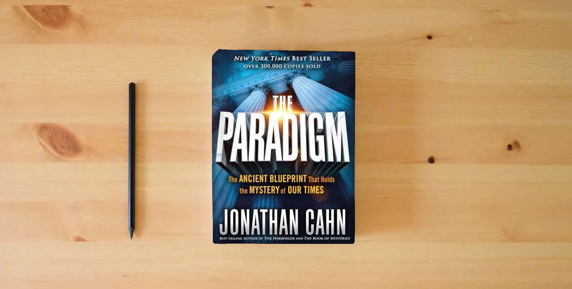 The book The Paradigm: The Ancient Blueprint That Holds the Mystery of Our Times is on the table
