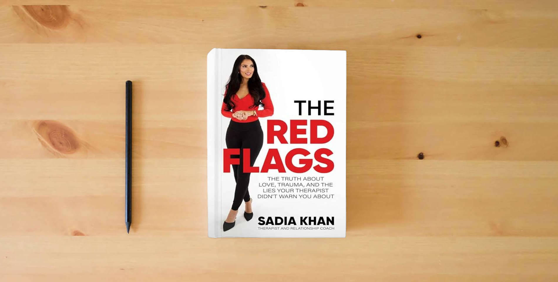 The book The Red Flags: The Truth About Love, Trauma, and the Lies Your Therapist Didn't Warn You About is on the table