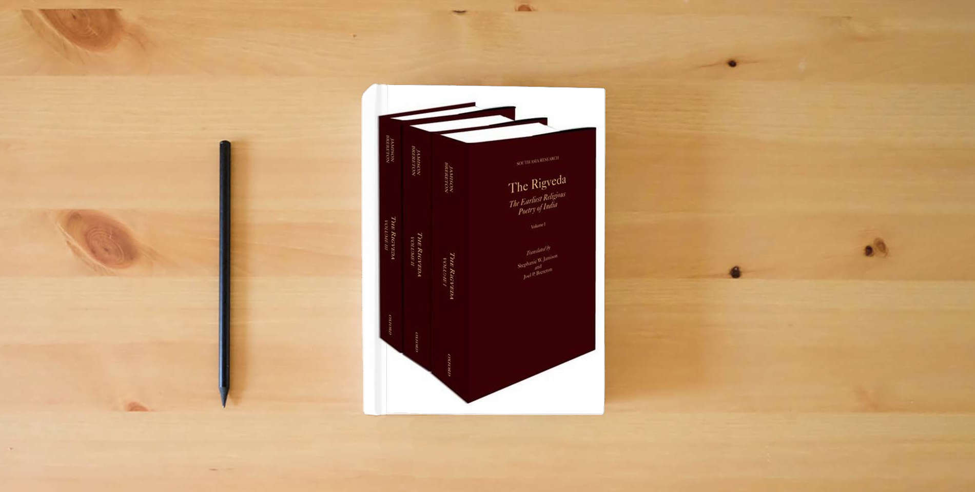 The book The Rigveda: 3-Volume Set (South Asia Research) is on the table