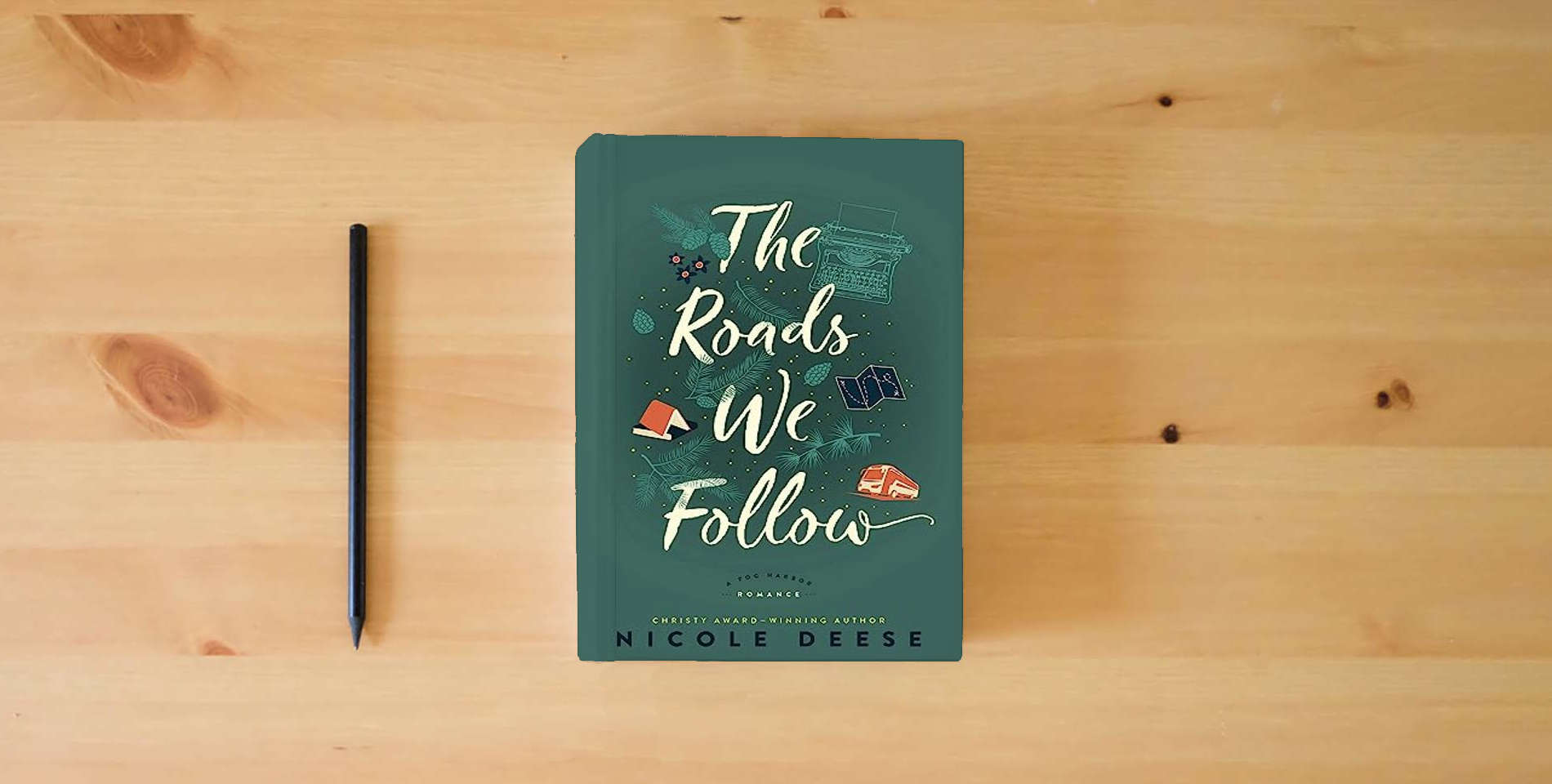 The book The Roads We Follow: (A Feel Good Contemporary Family Drama Romance Novel) (A Fog Harbor Romance) is on the table