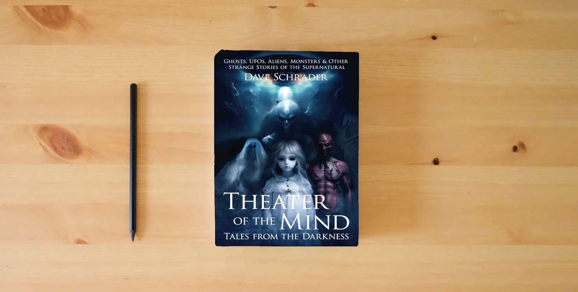 The book Theater of the Mind: Tales from the Darkness: Ghosts, UFOs, Aliens, Monsters, & Other Strange Stories of the Supernatural is on the table