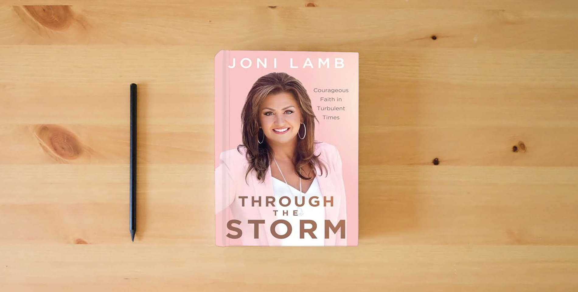 The book Through the Storm: Courageous Faith in Turbulent Times is on the table