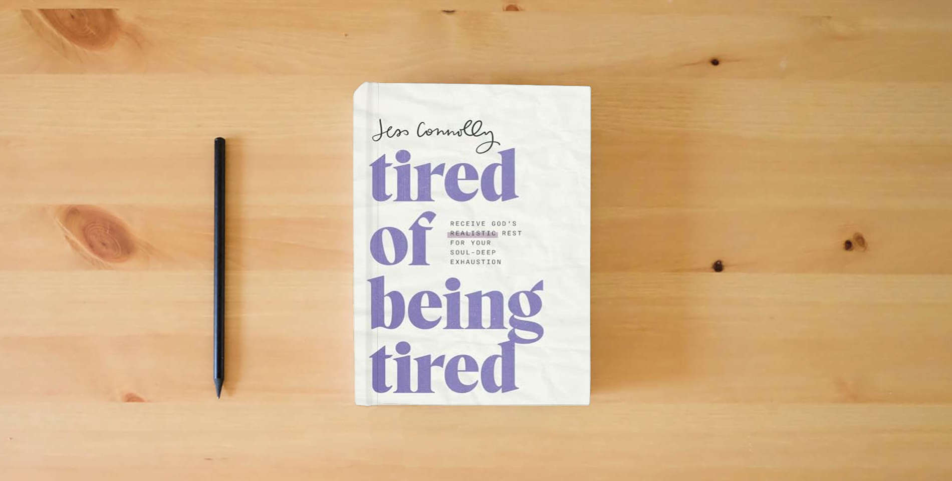 The book Tired of Being Tired: Receive God’s Realistic Rest for Your Soul-Deep Exhaustion is on the table