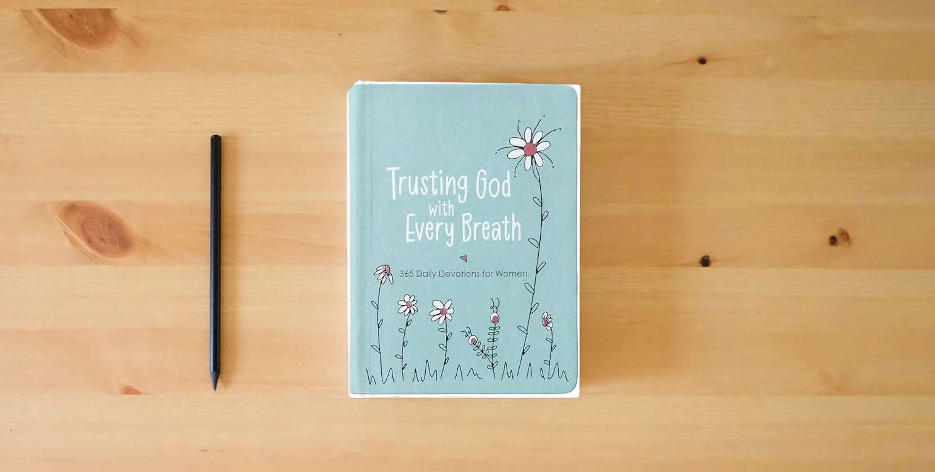 The book Trusting God With Every Breath: 365 Daily Devotions for Women – Find Hope for the Ups and Downs of Life is on the table