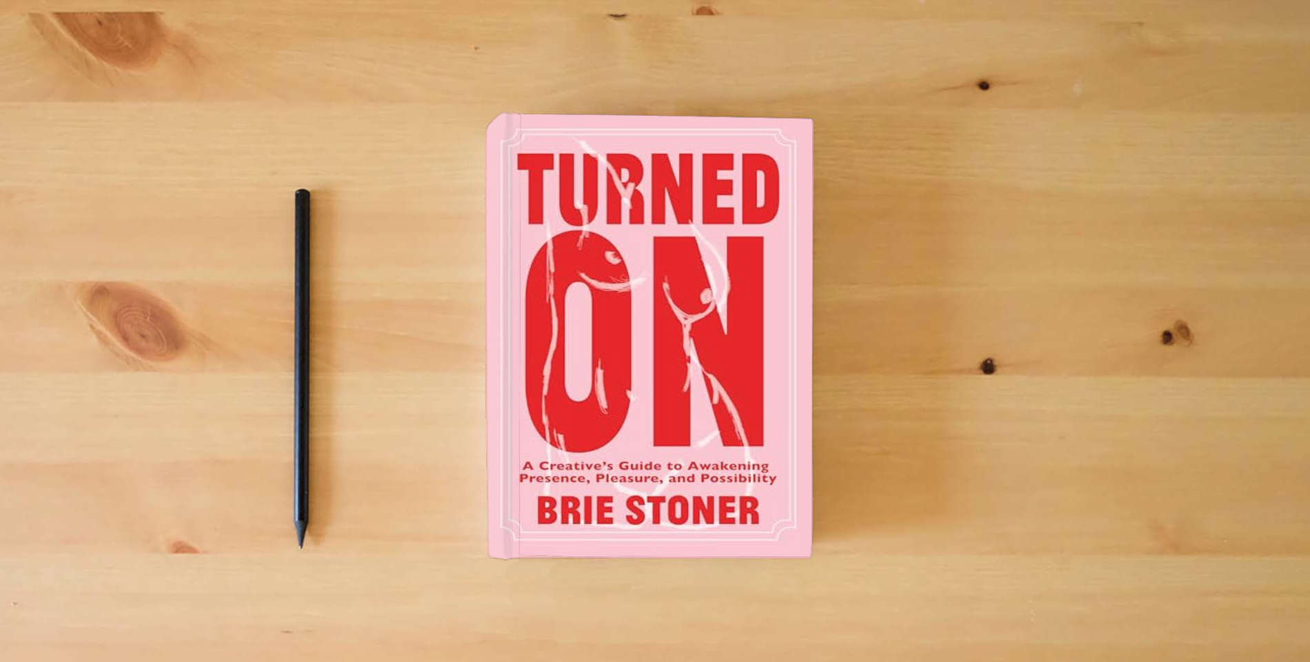 The book Turned On: A Creative’s Guide to Awakening Presence, Pleasure, and Possibility is on the table