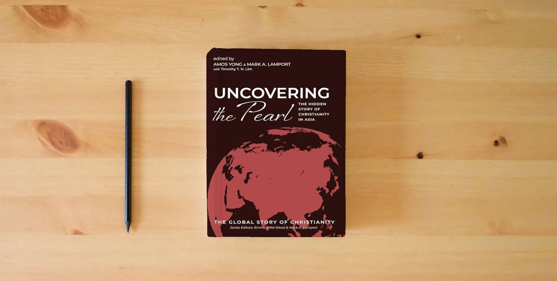 The book Uncovering the Pearl: The Hidden Story of Christianity in Asia (The Global Story of Christianity) is on the table