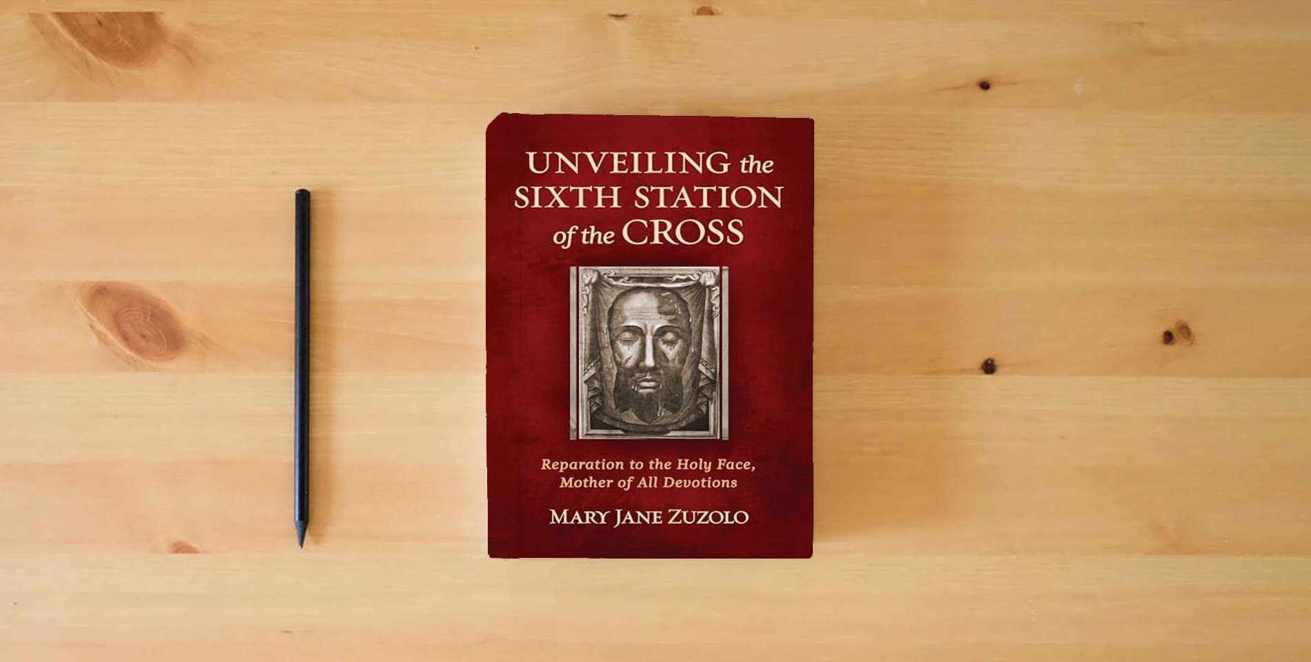The book Unveiling the Sixth Station of the Cross: Reparation to the Holy Face, Mother of All Devotions is on the table