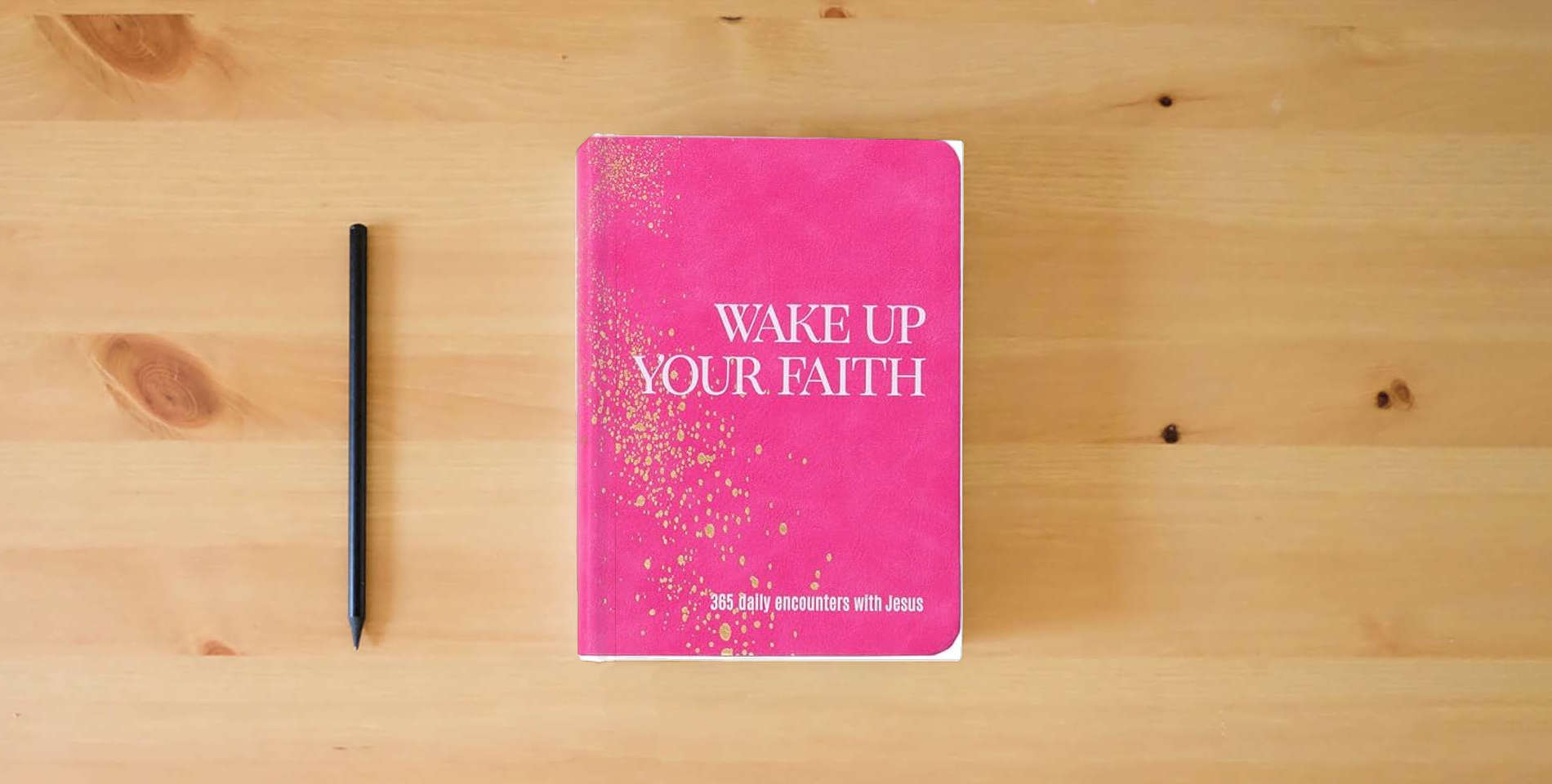 The book Wake Up Your Faith: 365 Daily Encounters with Jesus – A Journey of Spiritual Renewal and Divine Purpose is on the table