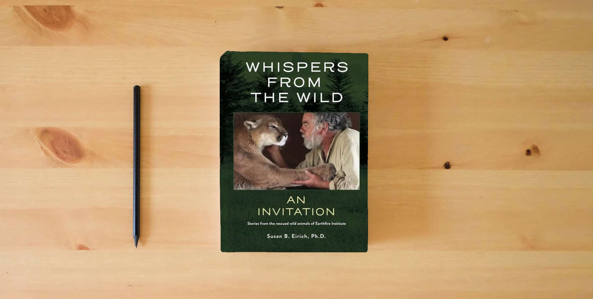 The book Whispers from the Wild an invitation: Stories From the Rescued Wild Animals of Earthfire Institute is on the table