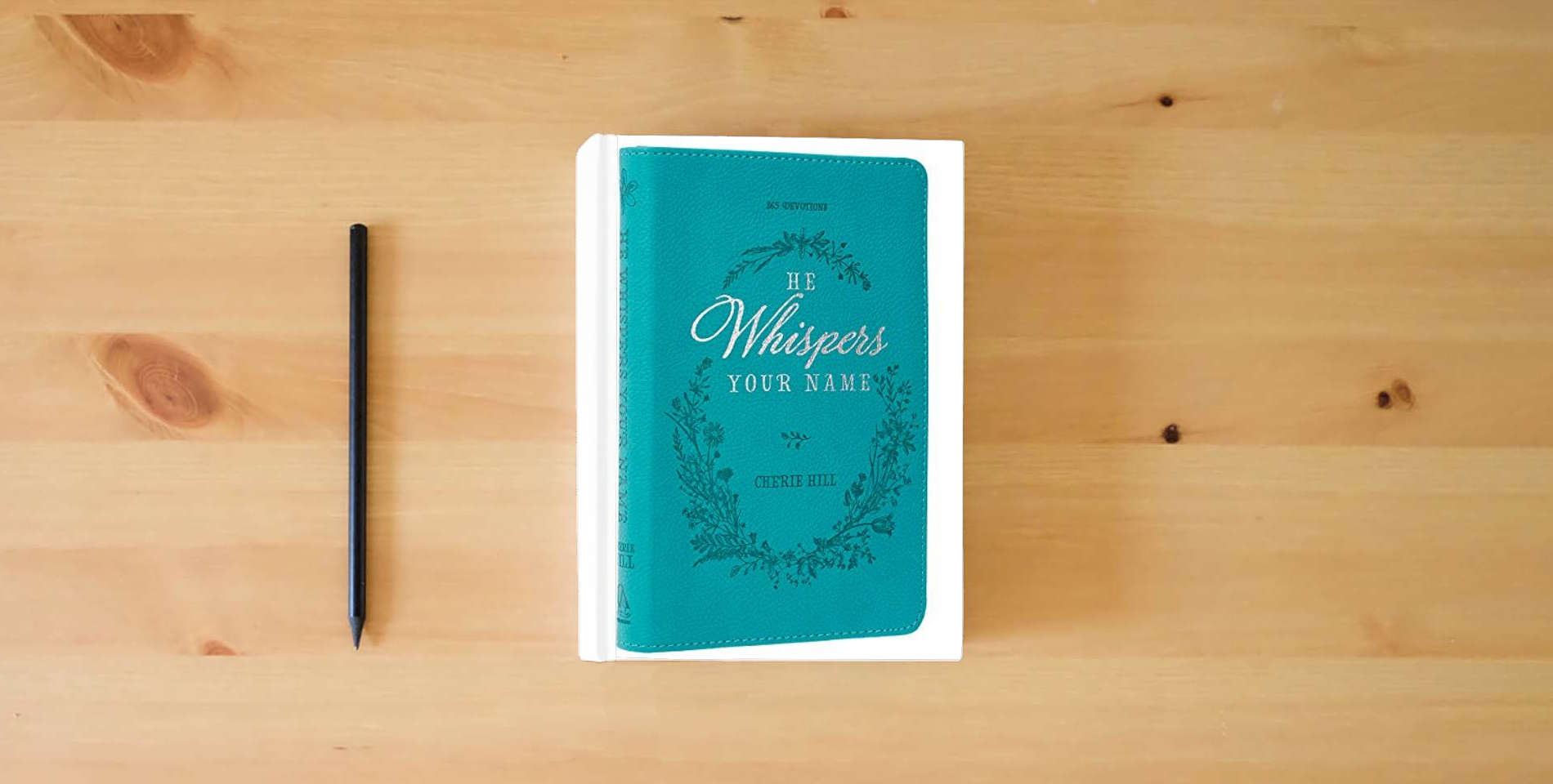 The book He Whispers Your Name 365 Devotions for Women - Hope and Comfort to Strengthen Your Walk of Faith - Teal Faux Leather Devotional Gift Book w/Ribbon Marker is on the table