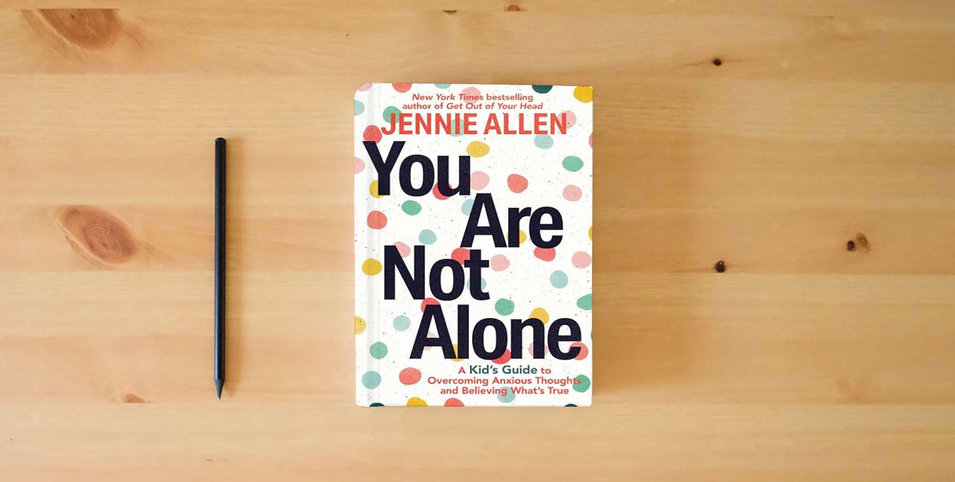 The book You Are Not Alone: A Kid's Guide to Overcoming Anxious Thoughts and Believing What's True is on the table