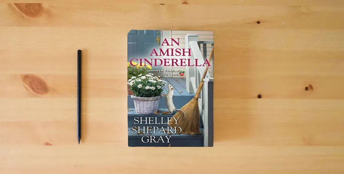 The book An Amish Cinderella: The Amish of Apple Creek} is on the table