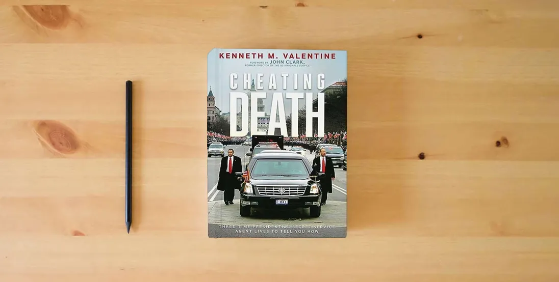 The book Cheating Death: Three-Time Presidential Secret Service Agent Lives to Tell You How} is on the table