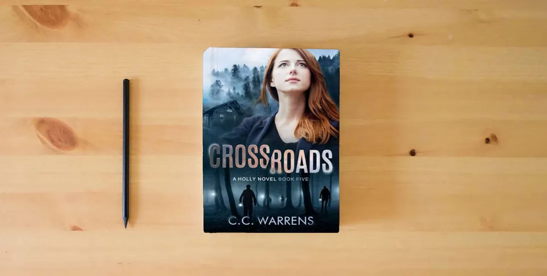 The book Crossroads: Christian Suspense (A Holly Novel)} is on the table