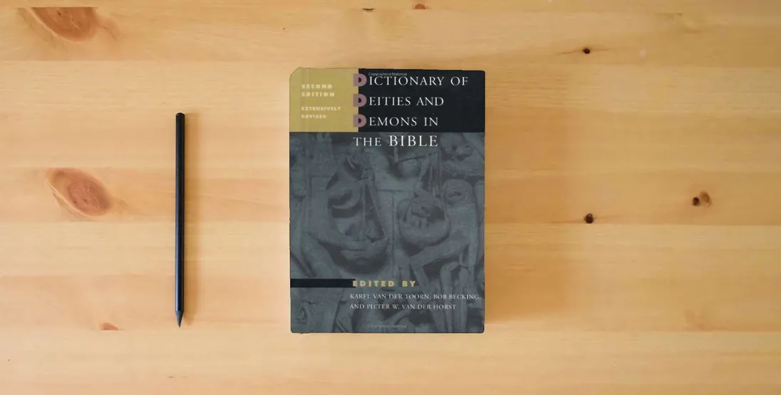 The book Dictionary of Deities and Demons in the Bible, Second Edition} is on the table