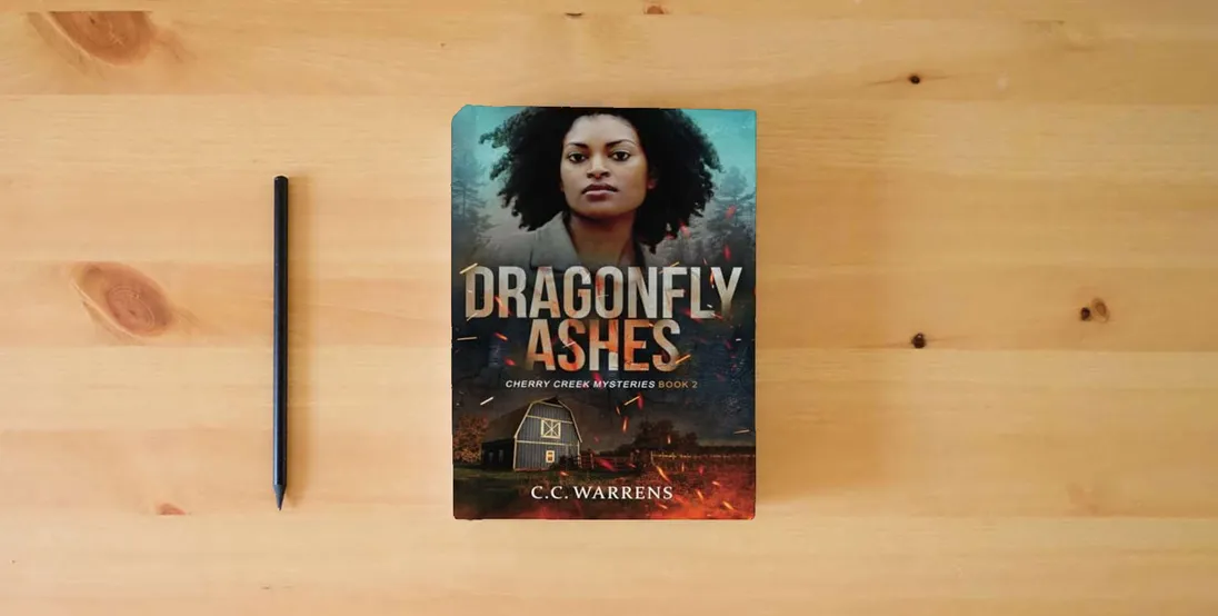 The book Dragonfly Ashes (Cherry Creek Mysteries)} is on the table