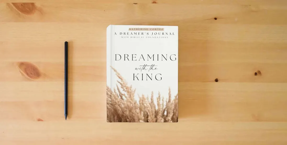 The book Dreaming With The King: A Dreamer's Journal with Biblical Foundations} is on the table