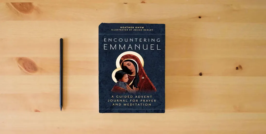 The book Encountering Emmanuel: A Guided Advent Journal for Prayer and Meditation} is on the table