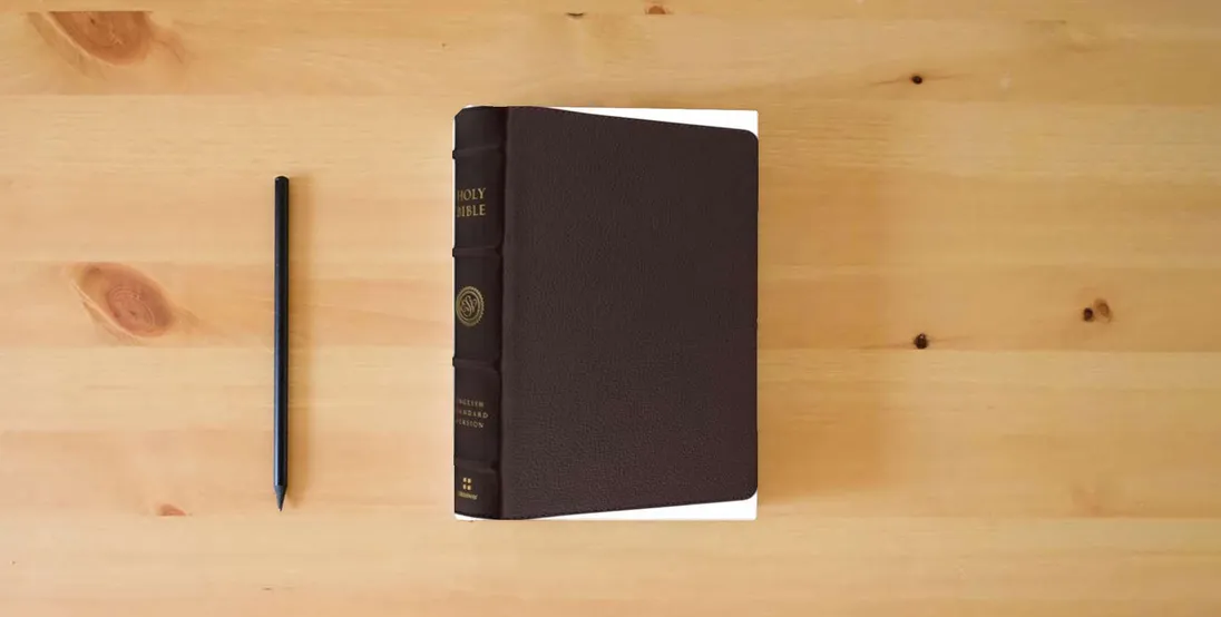 The book ESV Heirloom Bible, Gloria Dei: Single Column Edition (Calfskin, Mahogany)} is on the table