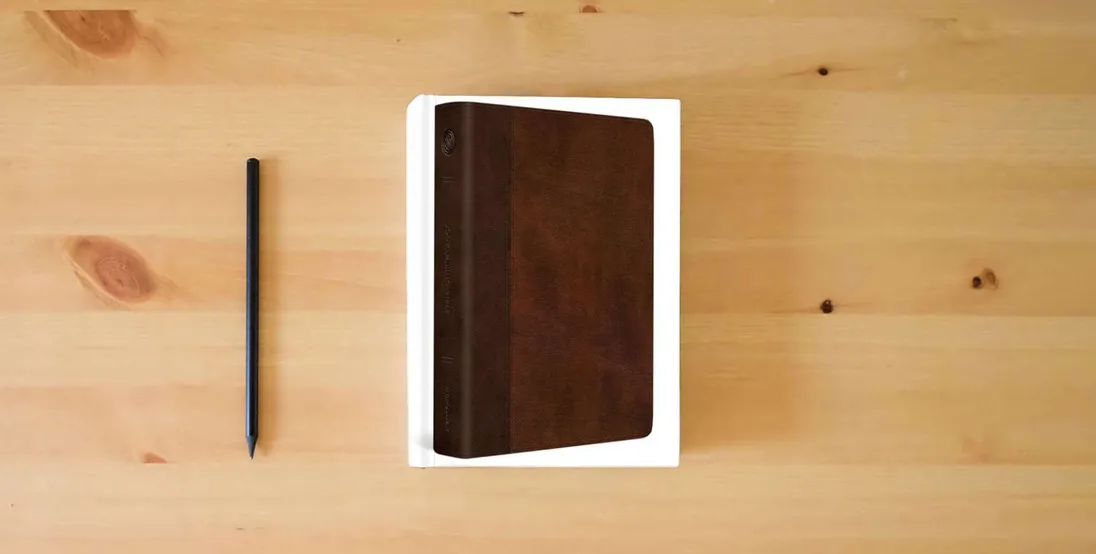 The book ESV Journaling Bible, Red Letter (TruTone, Brown/Tan, Timeless Design)} is on the table
