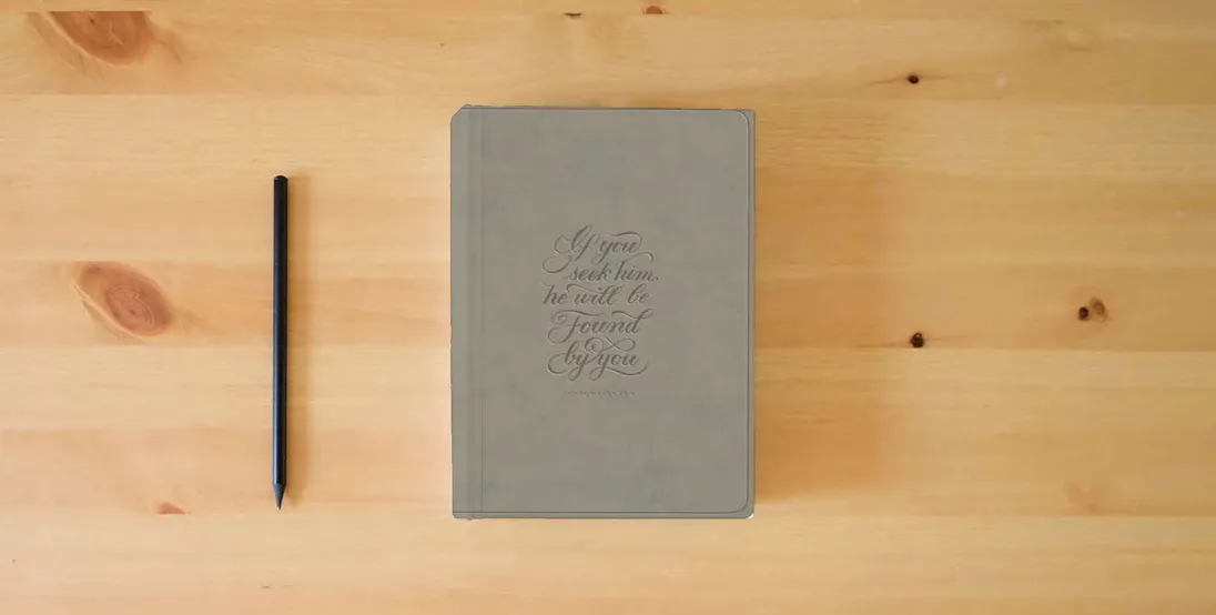 The book ESV Large Print Value Thinline Bible (TruTone, Stone, 1 Chronicles 28:9 Design)} is on the table