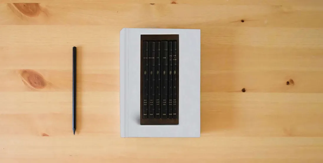 The book ESV Reader's Bible, Six-Volume Set (Cowhide over Board with Walnut Slipcase)} is on the table