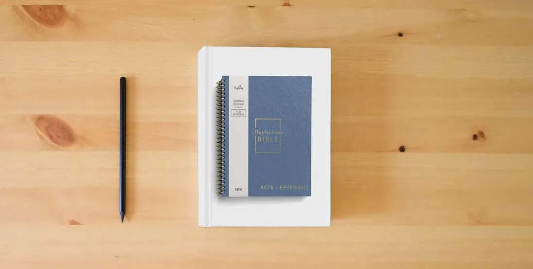 The book Illustrating Bible NIV Blue: Journal Your Way Through Acts - Ephesians} is on the table
