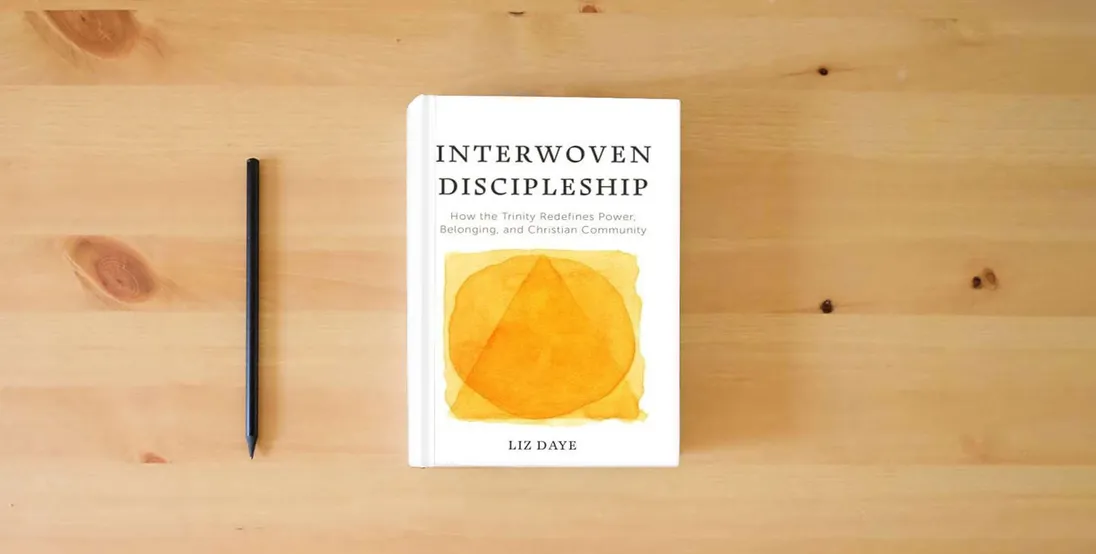 The book Interwoven Discipleship: How the Trinity Redefines Power, Belonging, and Christian Community} is on the table