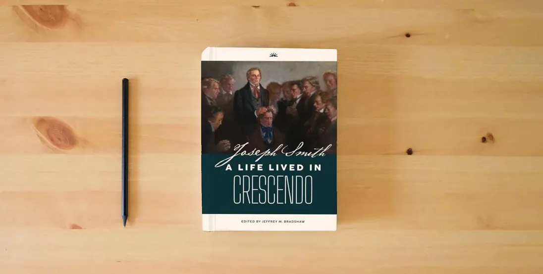 The book Joseph Smith: A Life Lived in Crescendo (Volume 2, Color, Hardback) (Joseph Smith: A Life Lived in Crescendo (Two Volumes))} is on the table