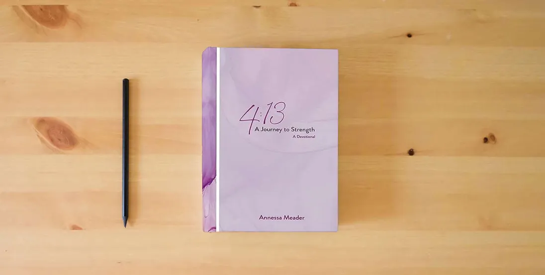 The book 4: 13: A Journey to Strength, A Devotional} is on the table