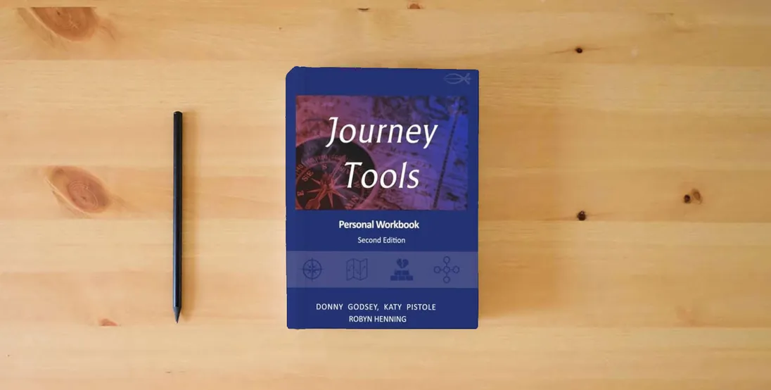 The book Journey Tools Workbook} is on the table