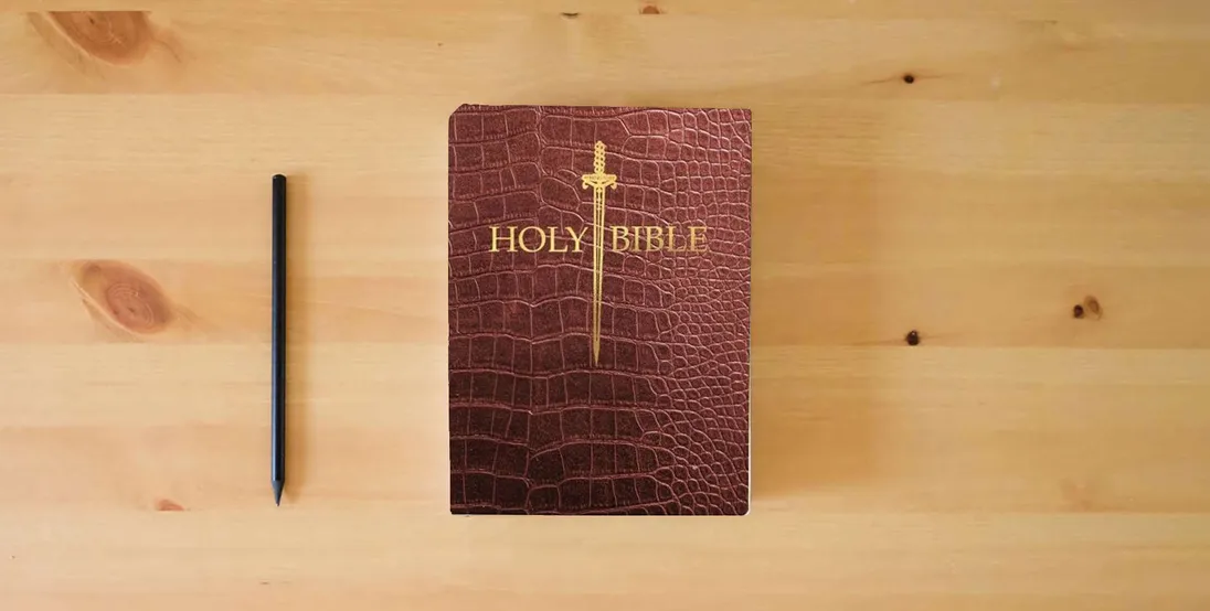 The book KJV Sword Bible, Large Print, Walnut Alligator Bonded Leather, Thumb Index: (Red Letter, Burgundy, 1611 Version) (King James Version Sword Bible)} is on the table