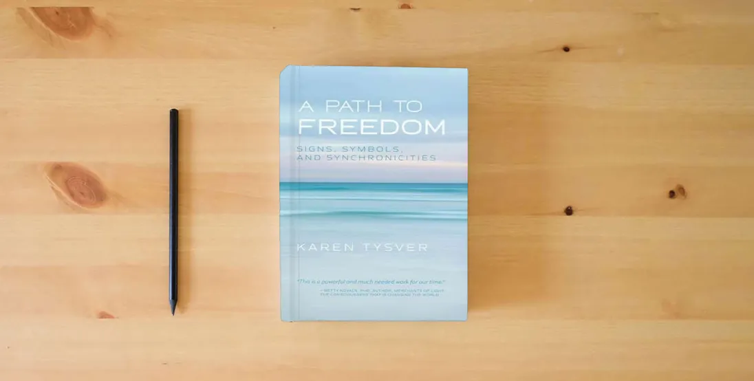 The book A Path to Freedom: Signs, Symbols, and Synchronicities} is on the table