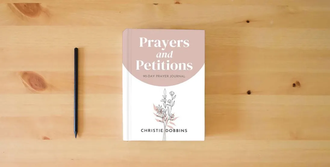 The book Prayers & Petitions: 90-Day Prayer Journal} is on the table