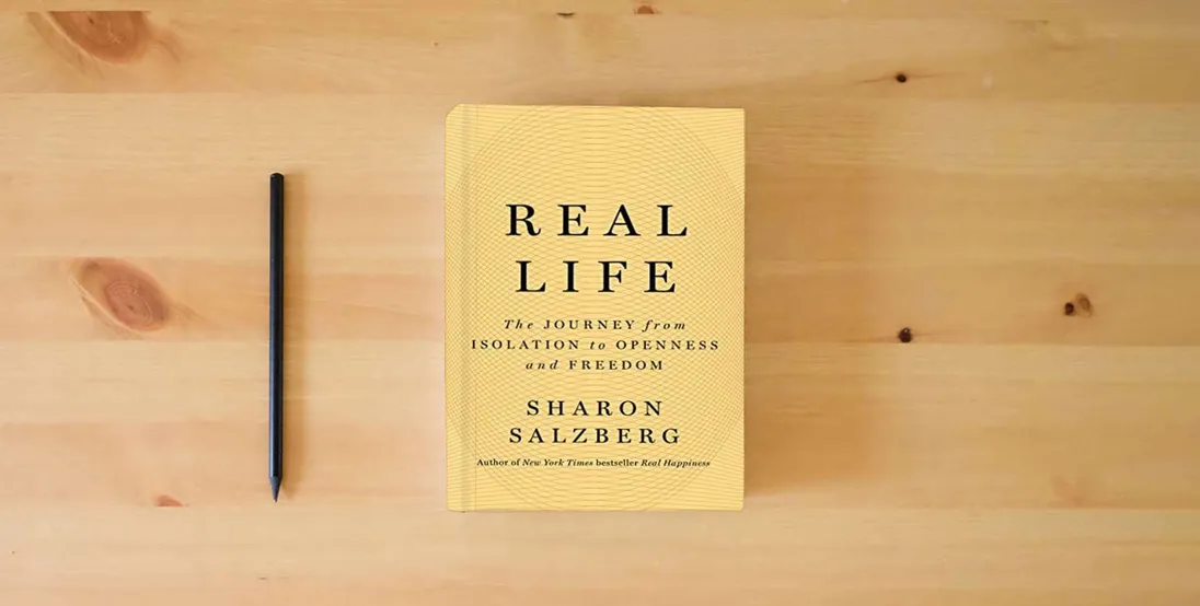 The book Real Life: The Journey from Isolation to Openness and Freedom} is on the table