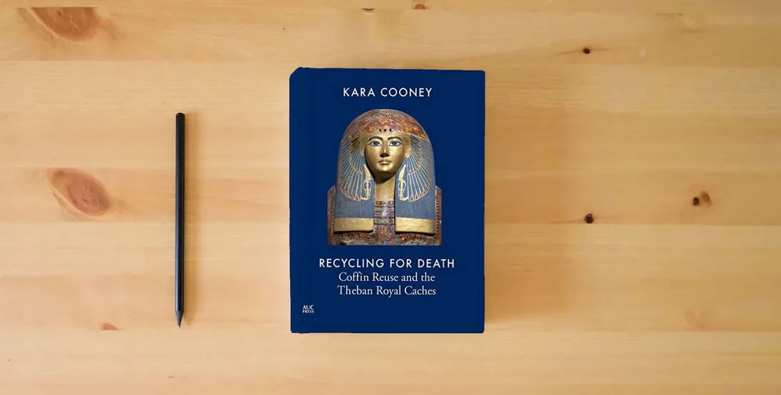 The book Recycling for Death: Coffin Reuse and the Theban Royal Caches} is on the table