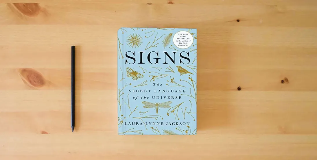 The book Signs: The Secret Language of the Universe} is on the table