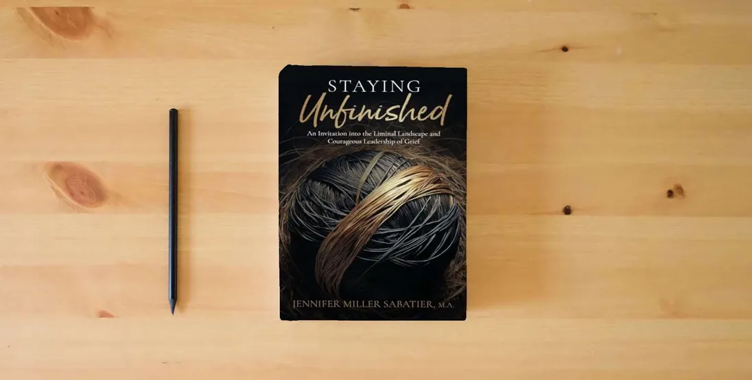 The book Staying Unfinished: An Invitation into the Liminal Landscape and Courageous Leadership of Grief} is on the table