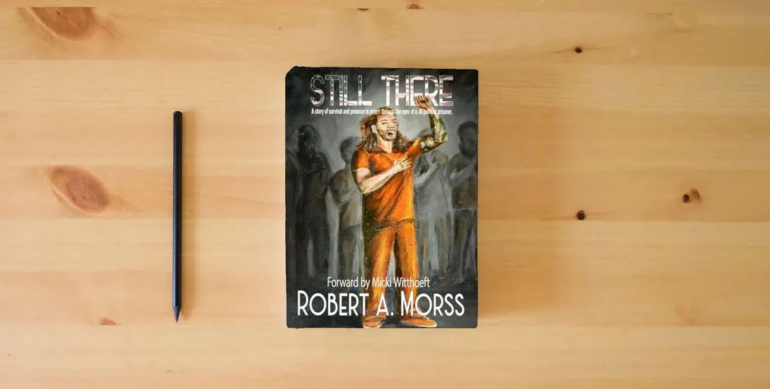 The book STILL THERE: A story of survival and penance in prison through the eyes of a J6 Political Prisoner} is on the table